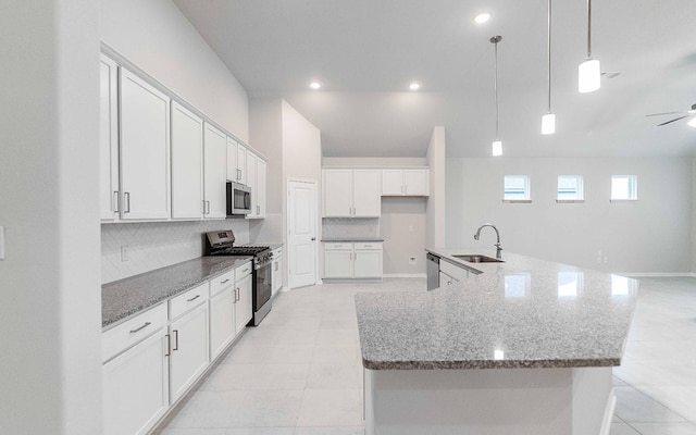 331 Riesling Dr, Alvin, TX 77511 - kitchen featuring appliances with stainless steel finishes, a sink, decorative backsplash, ceiling fan, and white cabinetry