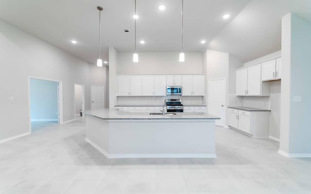 331 Riesling Dr, Alvin, TX 77511 - kitchen with appliances with stainless steel finishes, a spacious island, white cabinets, tasteful backsplash, and high vaulted ceiling