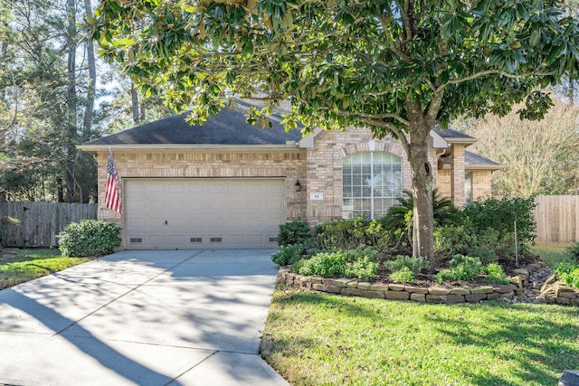 view of property hidden behind natural elements featuring driveway, a shingled roof, an attached garage, fence, and brick siding