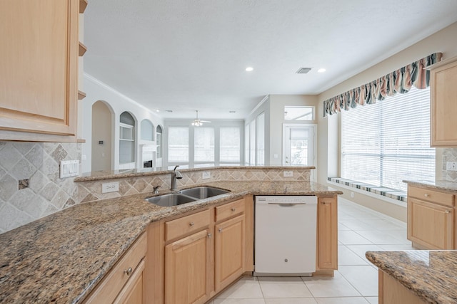 kitchen with visible vents, light brown cabinets, a sink, white dishwasher, and tasteful backsplash