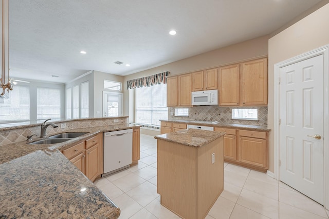 kitchen featuring tasteful backsplash, a healthy amount of sunlight, a sink, and white appliances