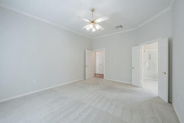 unfurnished room with visible vents, crown molding, baseboards, light colored carpet, and ceiling fan