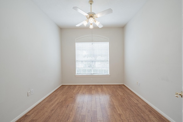 empty room with baseboards, a ceiling fan, and wood finished floors
