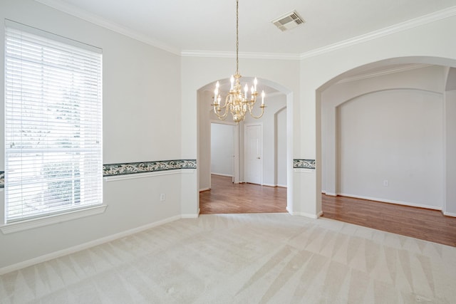 empty room featuring a wealth of natural light, visible vents, and arched walkways