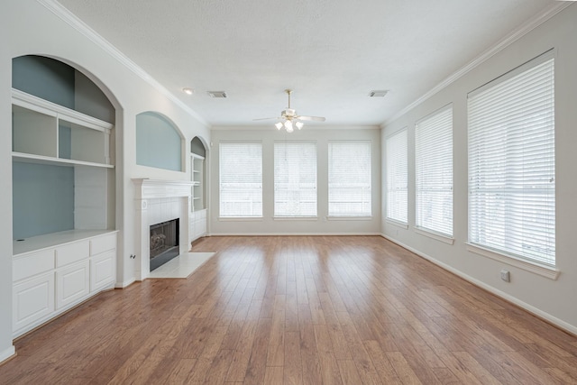 unfurnished living room with a fireplace with flush hearth, visible vents, a ceiling fan, baseboards, and hardwood / wood-style flooring