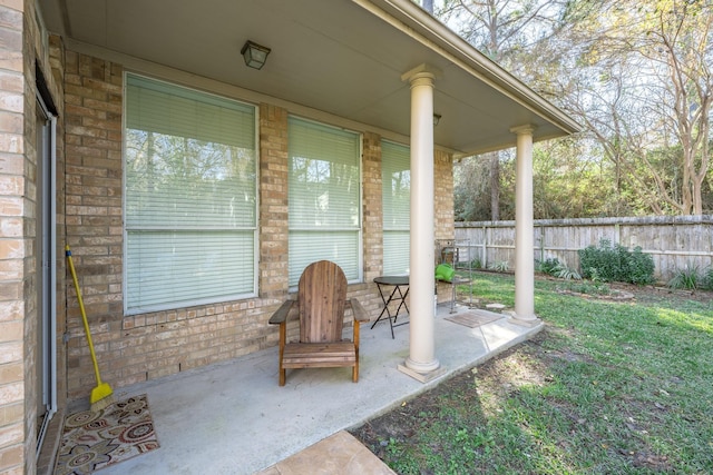 view of patio / terrace featuring fence and covered porch