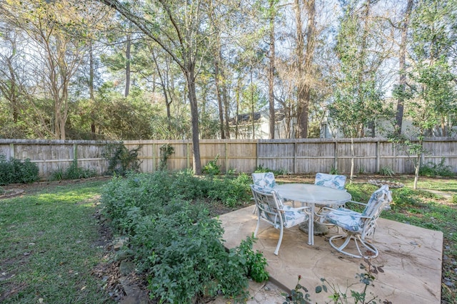 view of yard featuring a fenced backyard, a patio area, and outdoor dining area