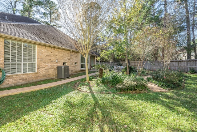 view of yard with central AC and a fenced backyard