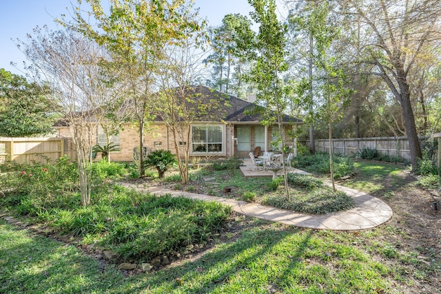 exterior space with brick siding, a patio area, and a fenced backyard