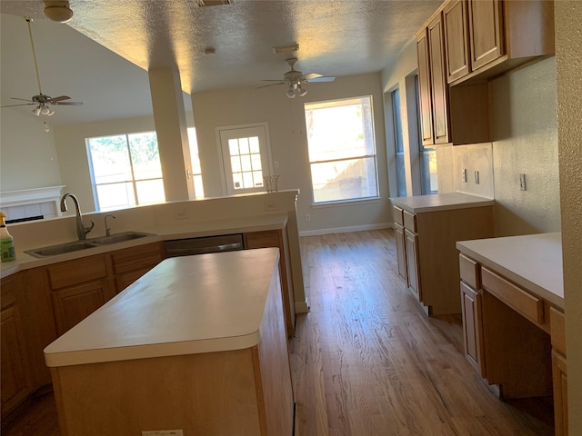 kitchen featuring light wood finished floors, dishwasher, a ceiling fan, and a sink
