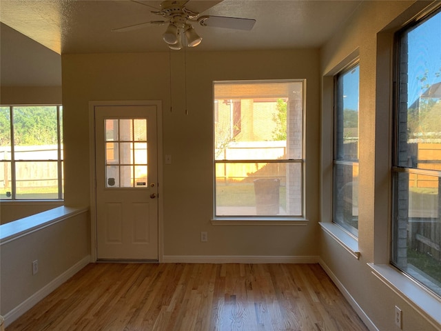 entryway featuring plenty of natural light, baseboards, wood finished floors, and a ceiling fan