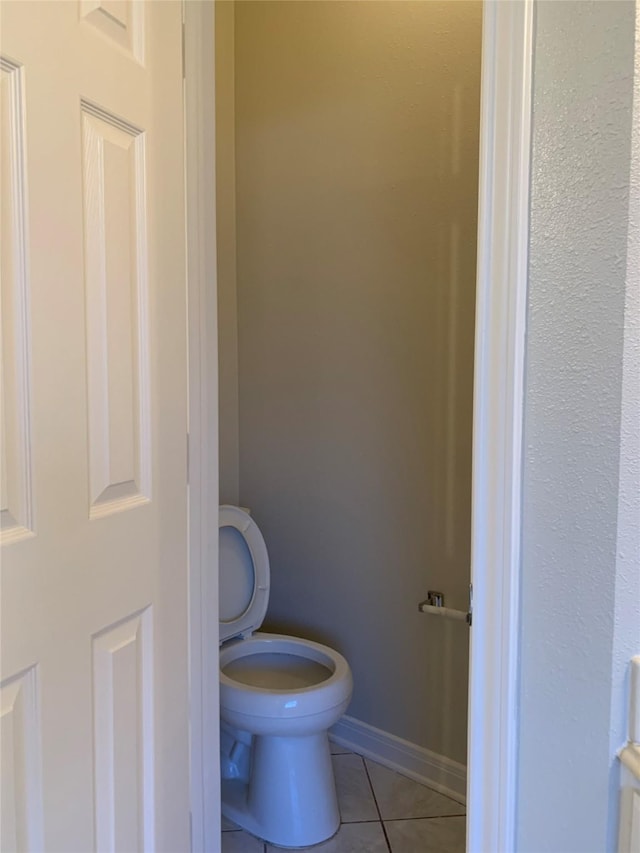 bathroom featuring tile patterned floors, baseboards, and toilet