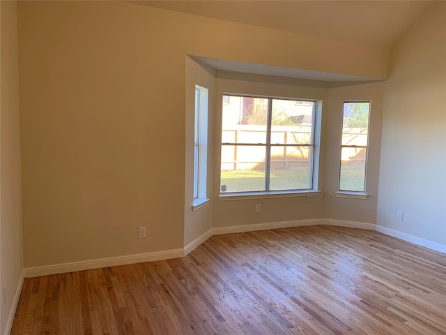 empty room featuring baseboards and light wood finished floors
