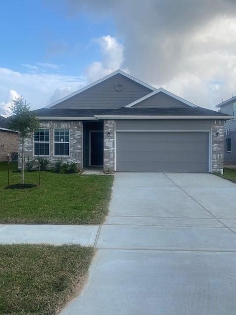 1425 17th Ave N, Texas City, TX 77590 - single story home with an attached garage, concrete driveway, a front lawn, and stone siding