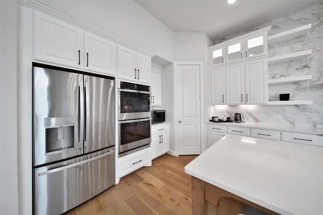 kitchen featuring open shelves, decorative backsplash, light wood-style floors, white cabinetry, and stainless steel appliances