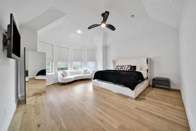 bedroom featuring a ceiling fan, visible vents, a baseboard heating unit, lofted ceiling, and light wood-style floors
