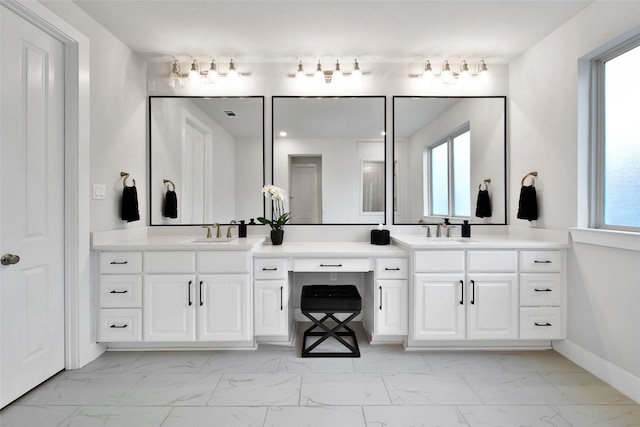 full bath with vanity, marble finish floor, and a healthy amount of sunlight
