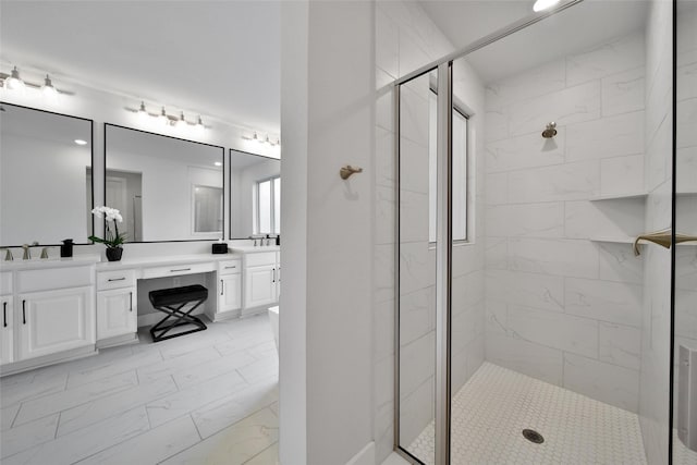 bathroom with double vanity, a shower stall, and marble finish floor