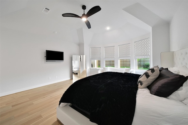 bedroom with visible vents, baseboards, a ceiling fan, light wood-style flooring, and vaulted ceiling