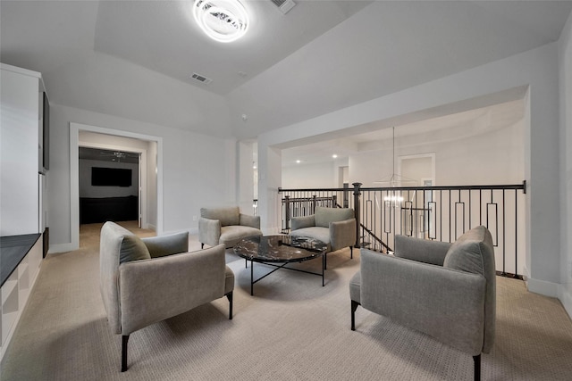 living area featuring baseboards, visible vents, and light colored carpet