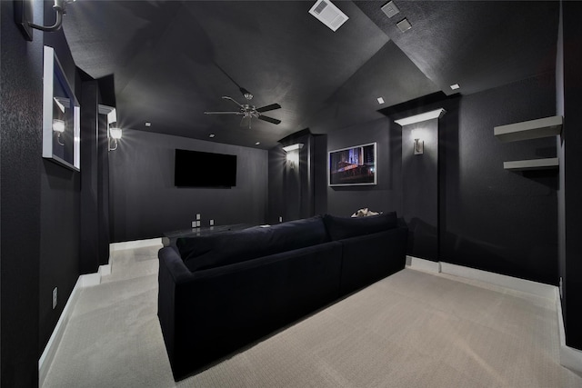 carpeted home theater featuring visible vents, baseboards, ceiling fan, and vaulted ceiling