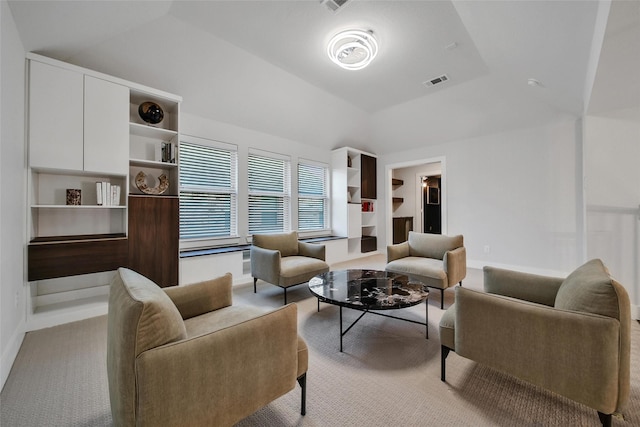 interior space featuring light colored carpet, baseboards, visible vents, and lofted ceiling