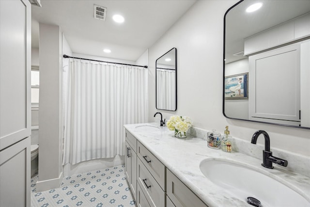 bathroom with recessed lighting, visible vents, toilet, and a sink