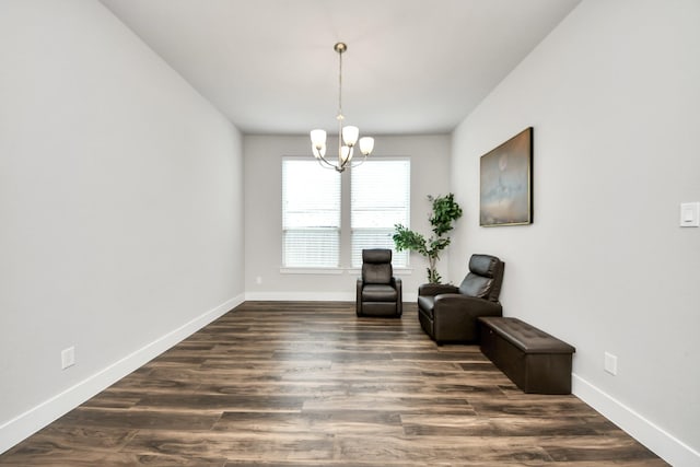 living area featuring baseboards, an inviting chandelier, and dark wood-style flooring