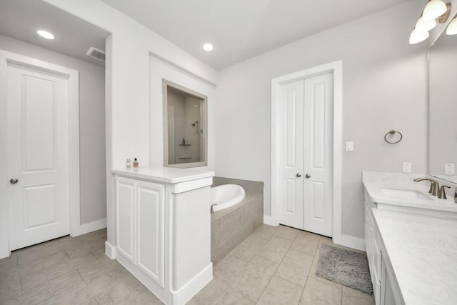 bathroom featuring baseboards, a garden tub, vanity, and tile patterned flooring