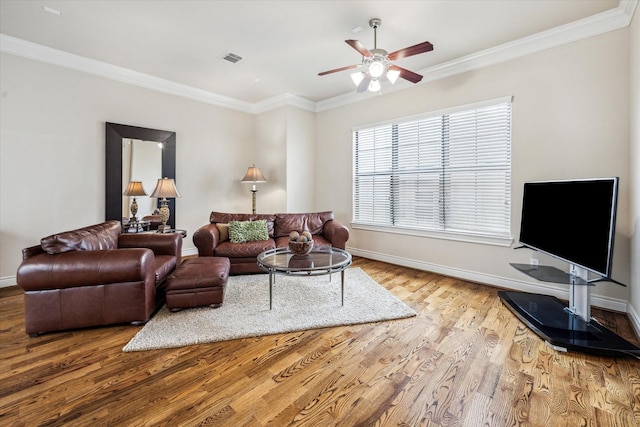 living area featuring ceiling fan, ornamental molding, wood finished floors, and visible vents