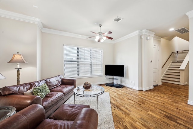 living area with a ceiling fan, visible vents, ornamental molding, and wood finished floors