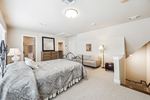 carpeted bedroom with visible vents, connected bathroom, and baseboards
