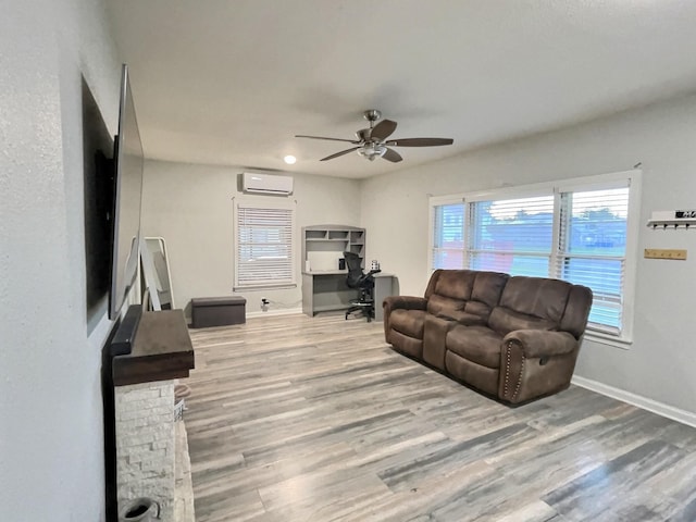 living area with recessed lighting, a wall mounted air conditioner, wood finished floors, a ceiling fan, and baseboards