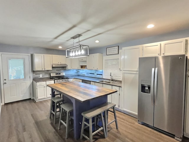 kitchen featuring a sink, wooden counters, stainless steel appliances, dark wood finished floors, and recessed lighting