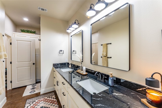 108 High Meadow Ct, Schulenburg, TX 78956 - bathroom featuring double vanity, visible vents, baseboards, and a sink