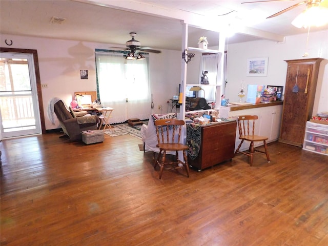 living room with a wealth of natural light, a ceiling fan, wood finished floors, and visible vents