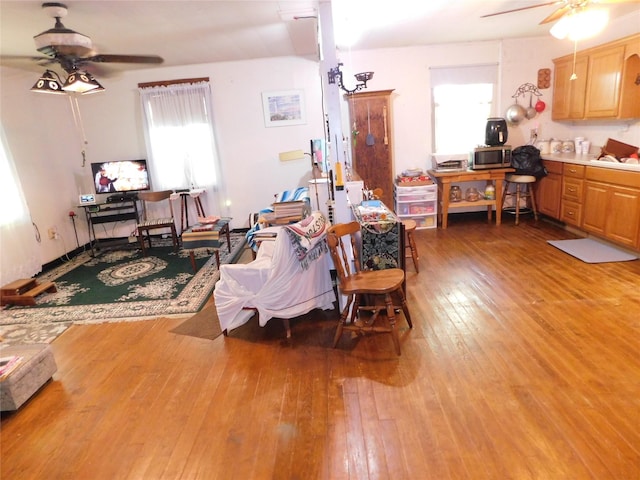 living area with light wood-style floors and ceiling fan