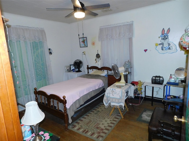 bedroom with wood finished floors, ceiling fan, and crown molding