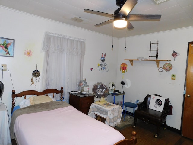 bedroom with ceiling fan, baseboards, crown molding, and wood finished floors
