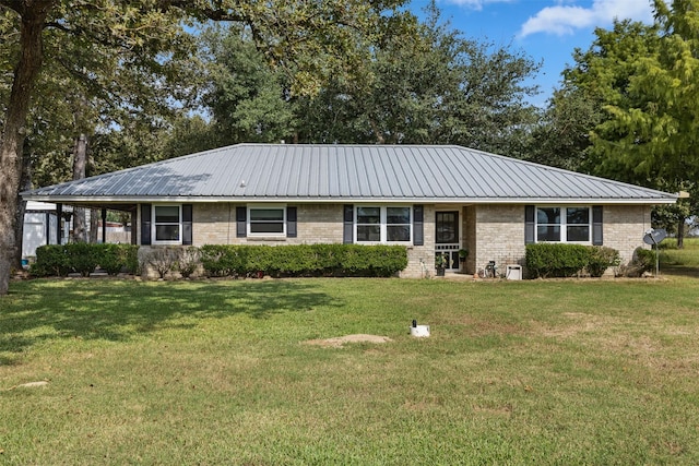 ranch-style home featuring brick siding, a front lawn, and metal roof