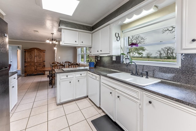 kitchen with white dishwasher, dark countertops, light tile patterned floors, and a sink