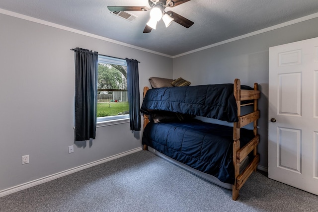 carpeted bedroom with ceiling fan, baseboards, ornamental molding, and visible vents