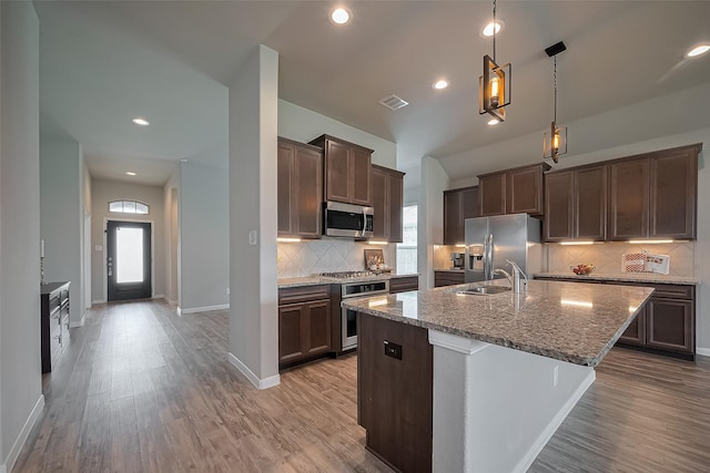 kitchen with a wealth of natural light, stainless steel appliances, light wood finished floors, and a sink