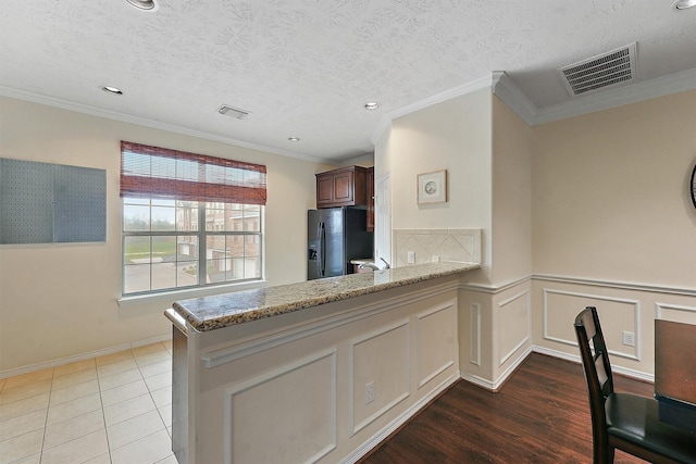 7818 Stoneyway Dr, Houston, TX 77040 - kitchen featuring black refrigerator with ice dispenser, light stone countertops, visible vents, and recessed lighting