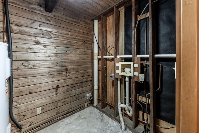 interior space featuring water heater, wood walls, unfinished concrete flooring, and wooden ceiling
