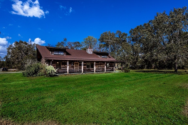 back of house with a shingled roof, log exterior, covered porch, and a yard
