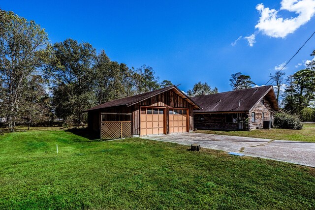 view of side of home with a yard and a detached garage