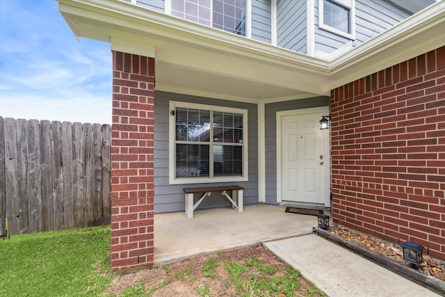 entrance to property with fence and brick siding