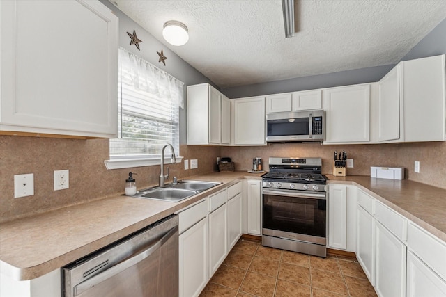 kitchen with a sink, stainless steel appliances, and white cabinetry