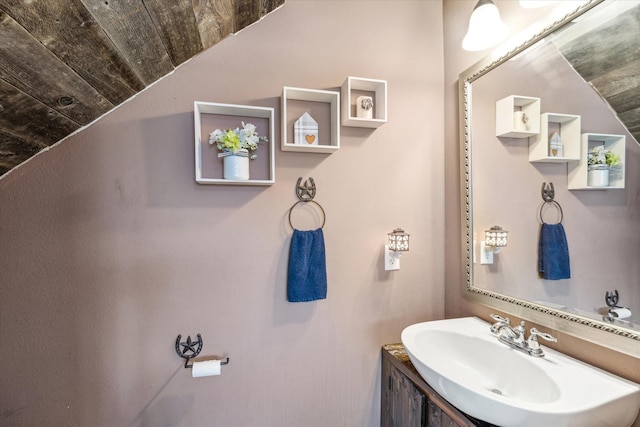 bathroom featuring a sink, vaulted ceiling, and wooden ceiling